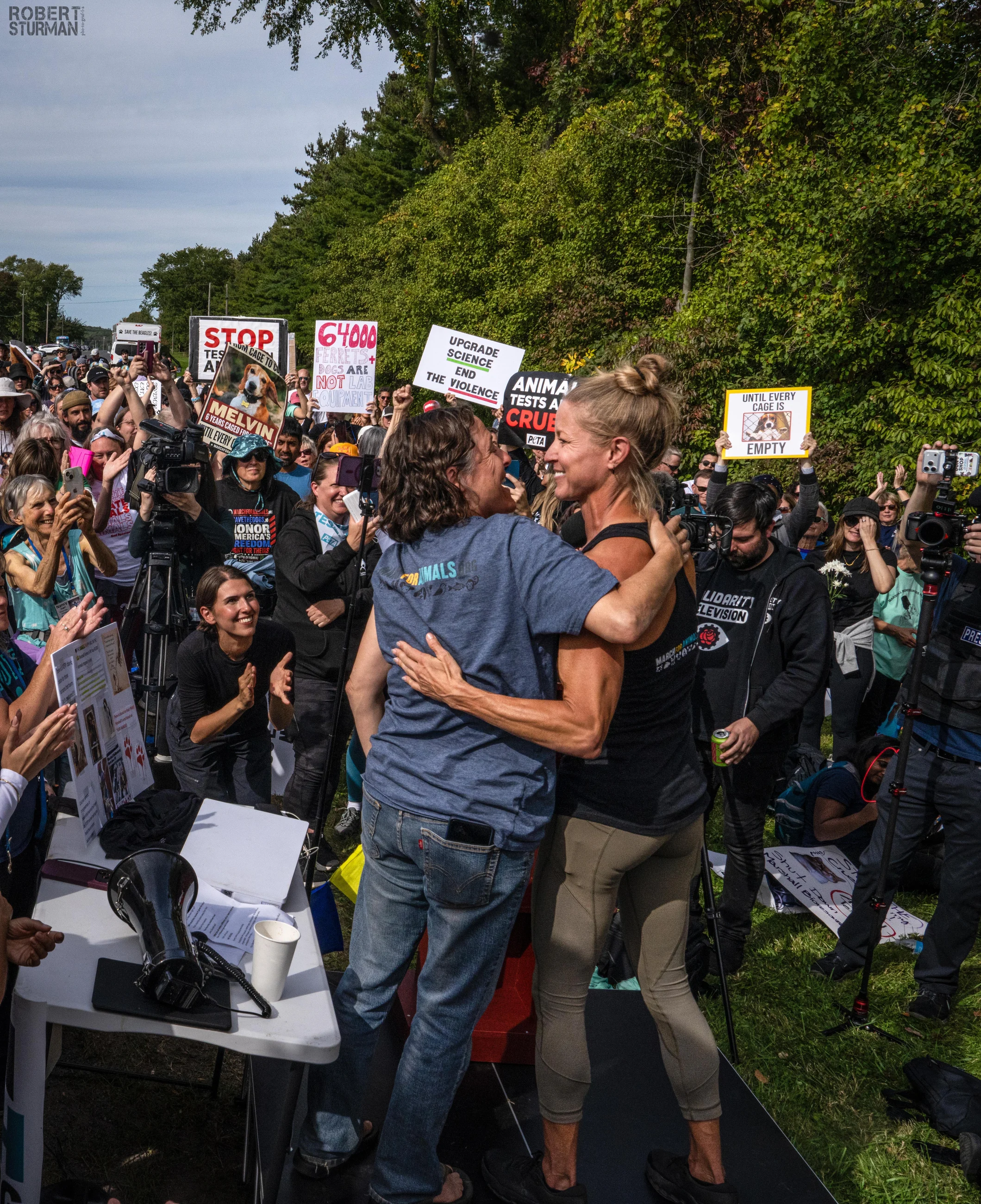 Ella Magers and Gretchen Primack embrace among supporters at an animal advocacy demonstration.